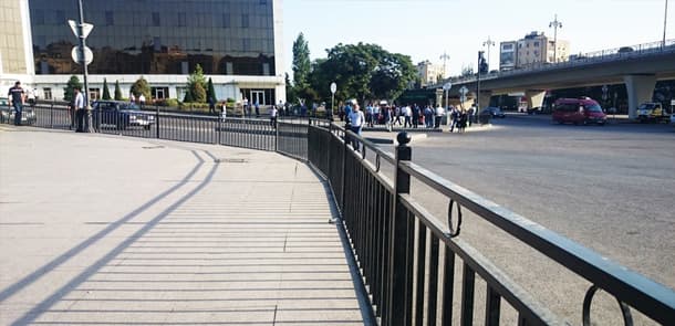 Yol polisi bəzi piyadaları geri qaytarır, bəzilərinin əlindən tutaraq yolu keçirir